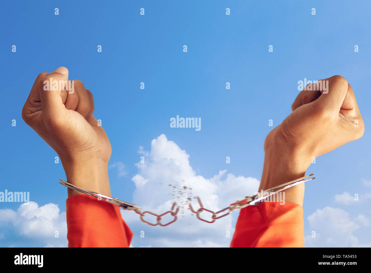 Concetto di libertà. le due mani del prigioniero con rotte manette per la libertà significato con cielo blu a sfondo Foto Stock