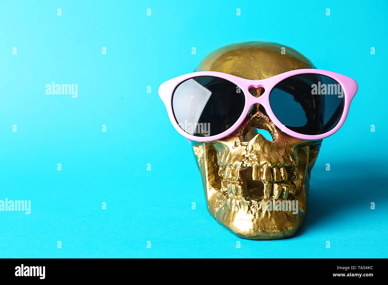 Golden teschio umano con gli occhiali da sole sul colore di sfondo Foto  stock - Alamy
