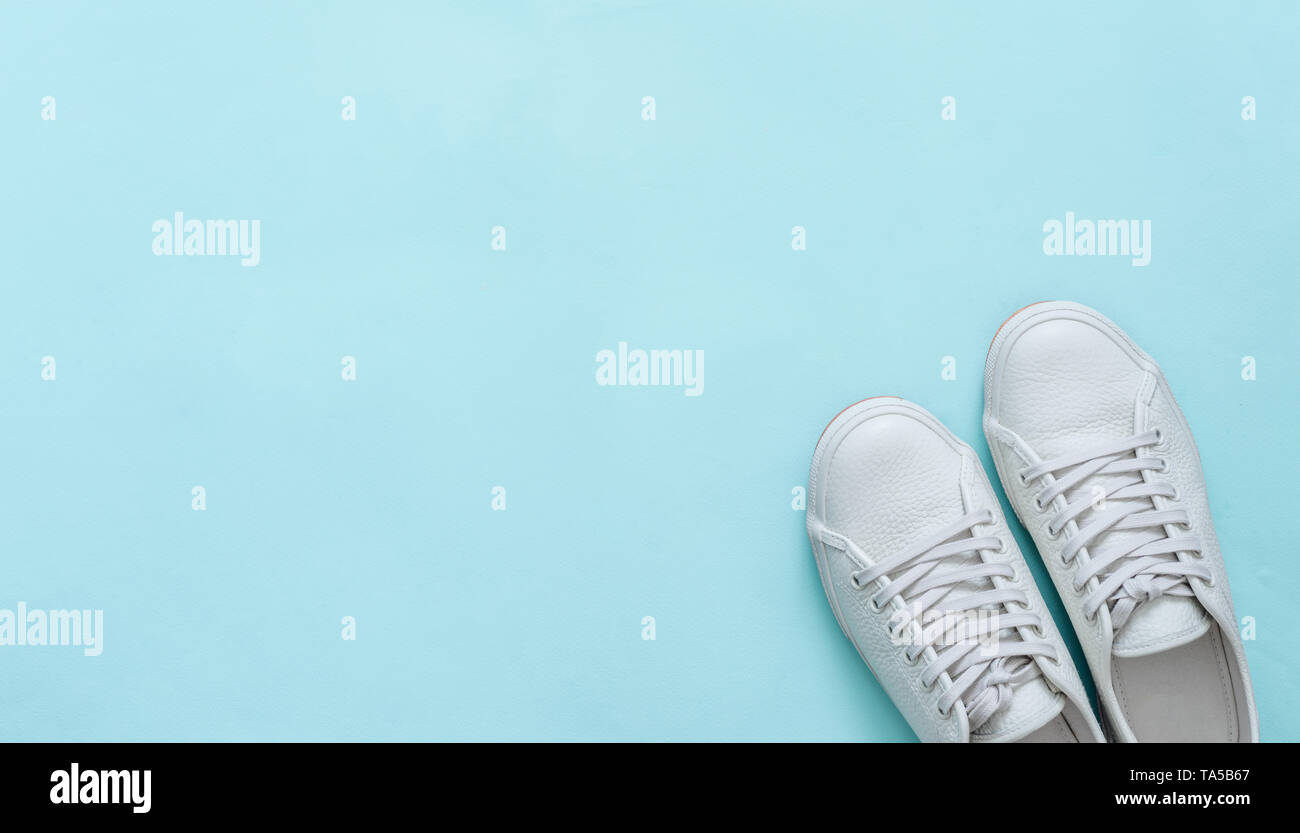 Bianco Pelle sneakers su sfondo blu. Coppia di moda bianco alla moda scarpe da ginnastica o sneakers con copia spazio per il testo o il design. Colpo di overhead di n Foto Stock