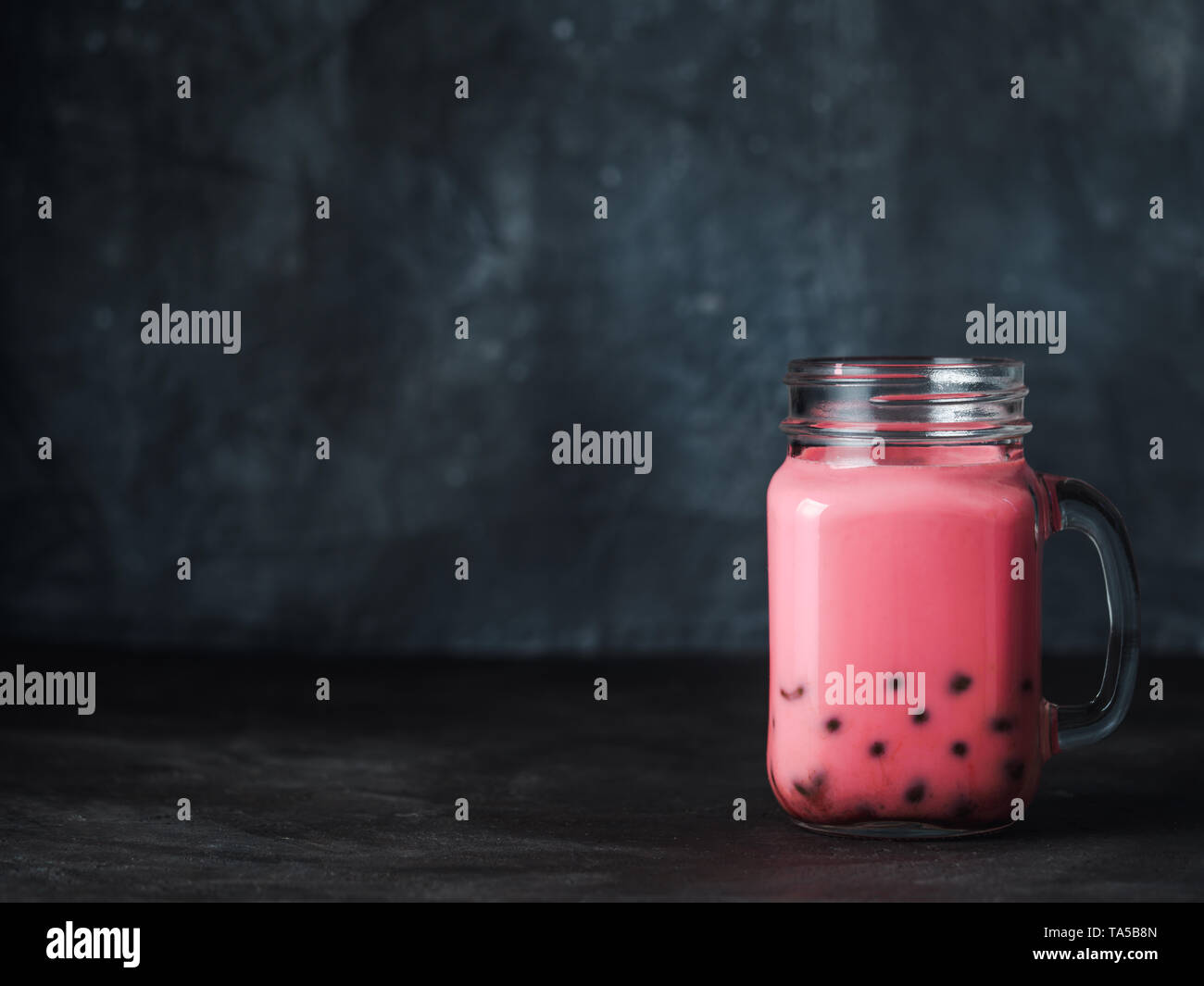 Latte in casa del tè di bolla con perle di tapioca palle. Popolari Taiwan tè bolle nel vetro mason jar con copia spazio per il testo. Bubble tea on dark backgrou Foto Stock