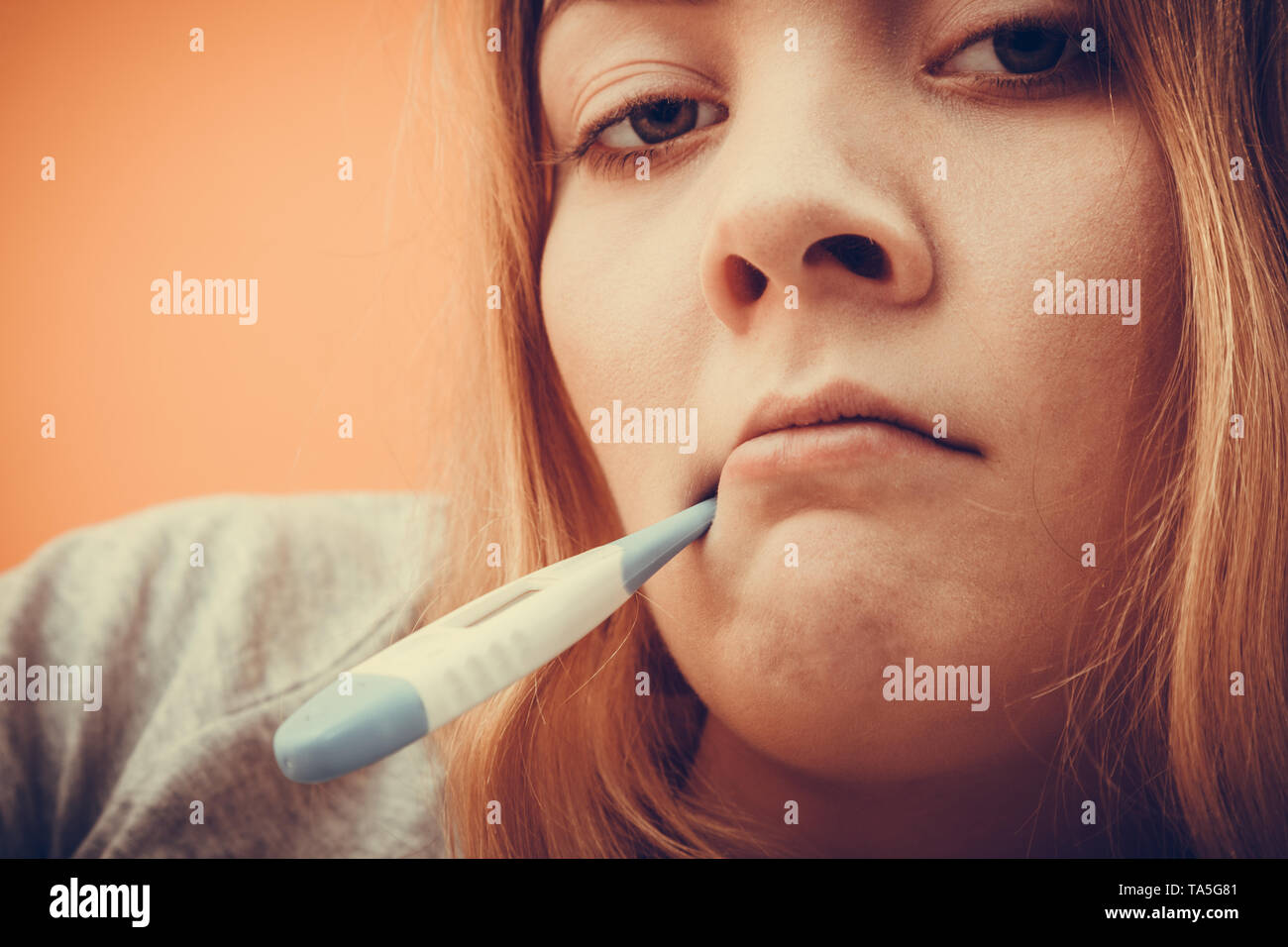 Malati ill donna con il termometro digitale in bocca. Ragazza giovane con  febbre alta temperatura di misurazione. Salute. Instagram filtro Foto stock  - Alamy