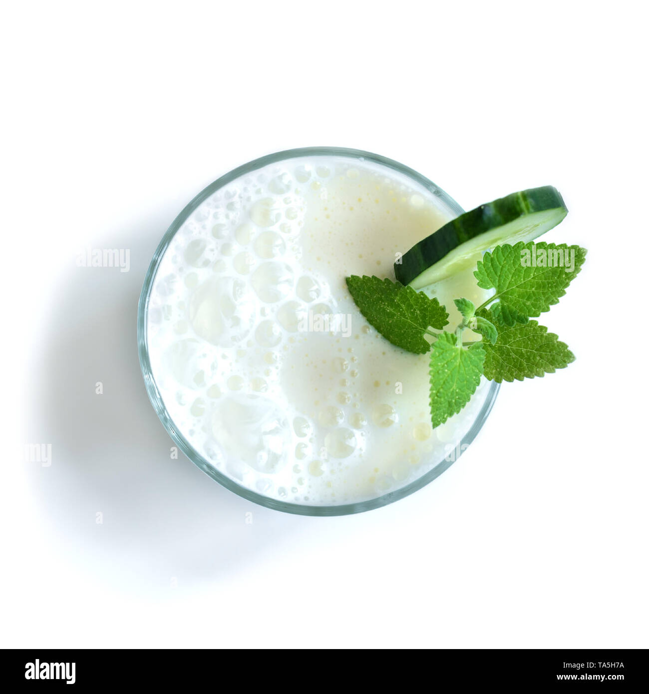 Ayran, yogurt fatto in casa bevanda (kefir, lassi) con la menta e cetrioli - estate sani rinfrescanti drink freddo, vista dall'alto, isolato su bianco. Foto Stock