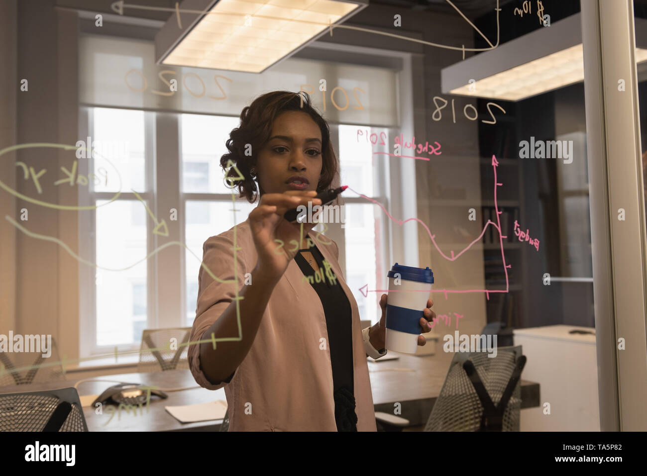 Imprenditrice iscritto sulla parete di vetro Foto Stock