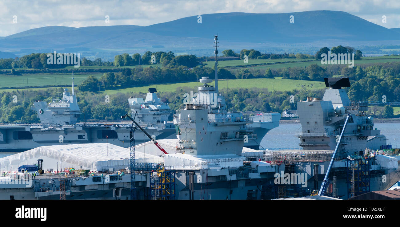 Rosyth, Scotland, Regno Unito. 22 Maggio, 2019. Portaerei HMS Queen Elizabeth ormeggiato a Rosyth nel fiume Forth dopo aver lasciato il bacino di carenaggio ieri dopo una visita a casa sua porta. Lei lascerà il via oggi e tornare al mare in preparazione per Westlant 19 deployment che è progettato per concentrarsi sulle operazioni del suo F-35 degli aerei da caccia. Nella foto; rara vista sia della Royal Navy di portaerei. HMS Queen Elizabeth e in primo piano il sistema HMS Prince of Wales ancora in costruzione nel cantiere di Rosyth. Credito: Iain Masterton/Alamy Live News Foto Stock