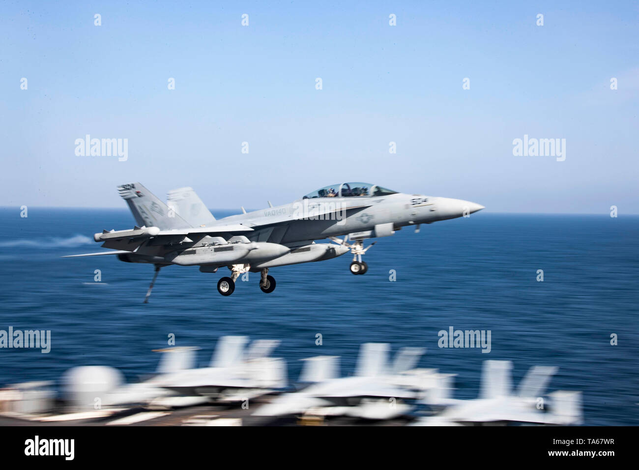 Golfo di Oman. 22 Maggio, 2019. Un U.S. Navy F/A-18F Super Hornet fighter aircraft da i patrioti di Attacco Elettronico Squadron 140 vola sopra la Nimitz-class portaerei USS Abraham Lincoln prima dello sbarco durante le operazioni 22 maggio 2019 nel Golfo di Oman. Il joint strike gruppo è parte delle forze aggiuntive essendo inviato in Medio Oriente per contrastare ciò che Trump gestione chiamate chiare indicazioni di minacce dall'Iran. Credito: Planetpix/Alamy Live News Foto Stock