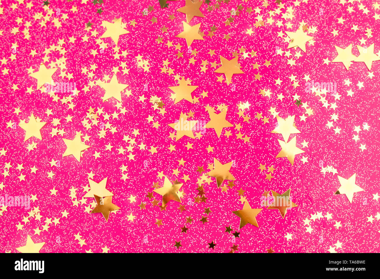 Golden Star confetti sul rosa fucsia sfondo. Per le feste con sfondo incandescente stelle. Foto Stock