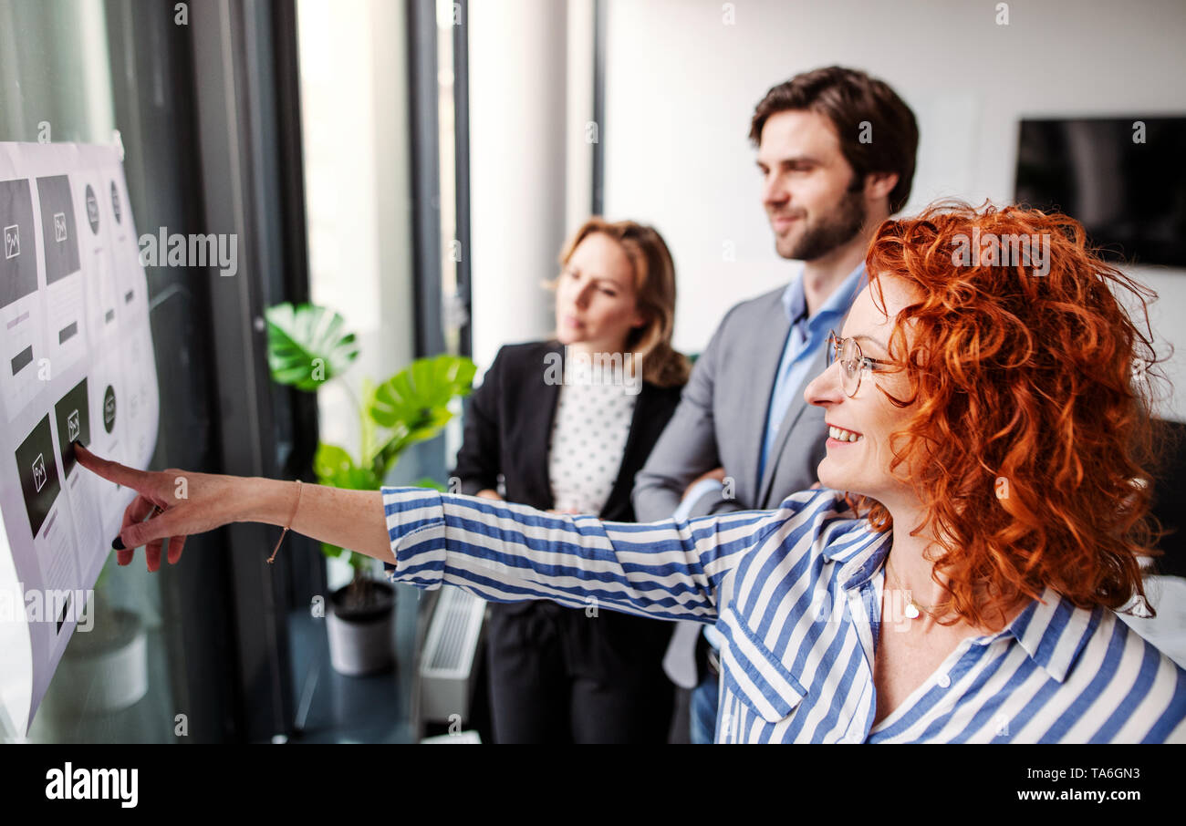 Un gruppo di giovani uomini di affari in un ufficio, il brainstorming. Foto Stock