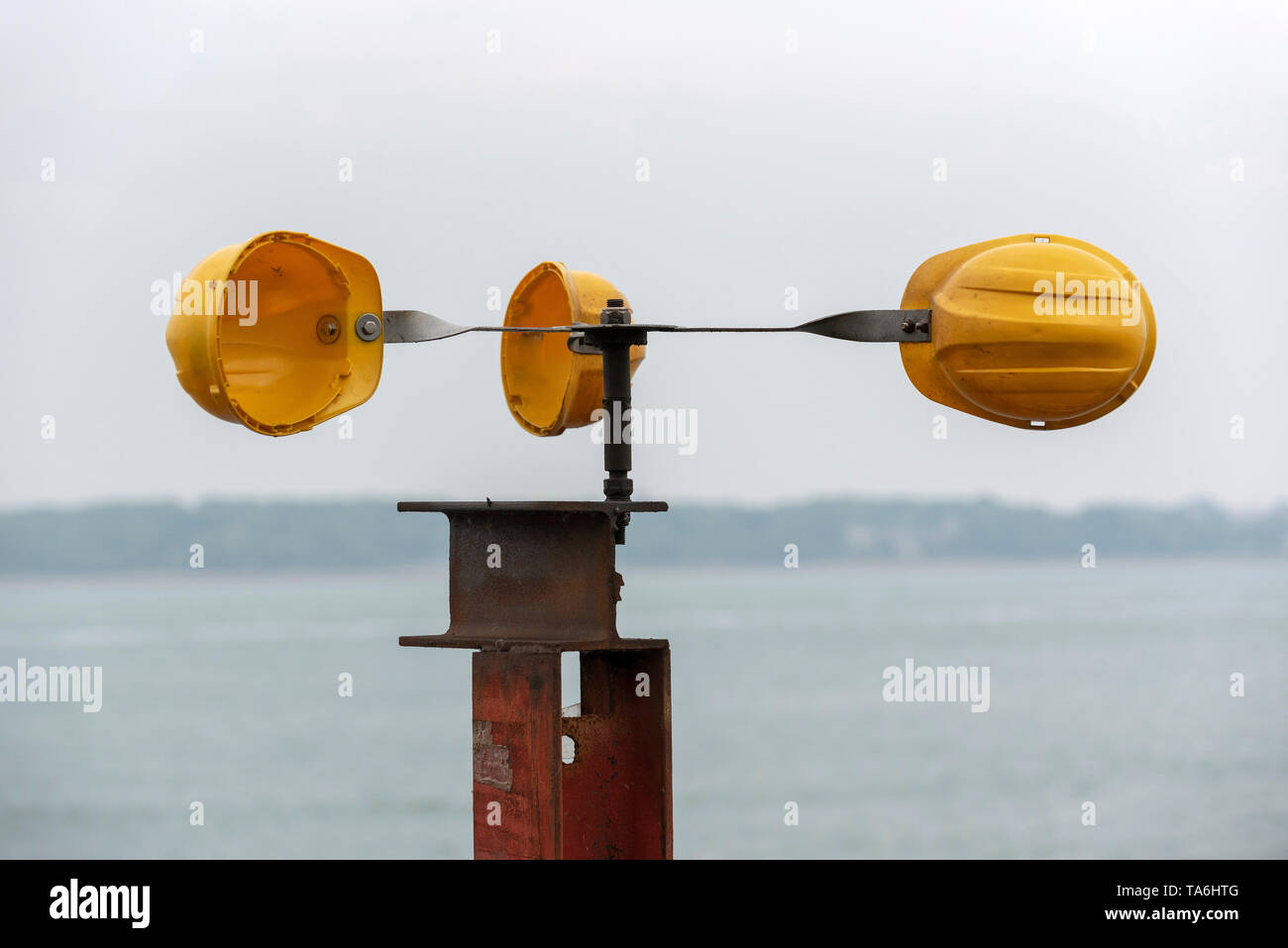 Southampton, Regno Unito, maggio 2019. Tre gialli duro cappelli imbullonate insieme per formare una casa fatta di vento, il dispositivo di misura alla fine del molo di Hythe. Foto Stock