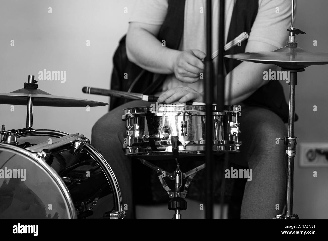 Bianco e nero live musica di sottofondo, il batterista suona con bacchette un drum set. Primo piano con morbida messa a fuoco selettiva Foto Stock