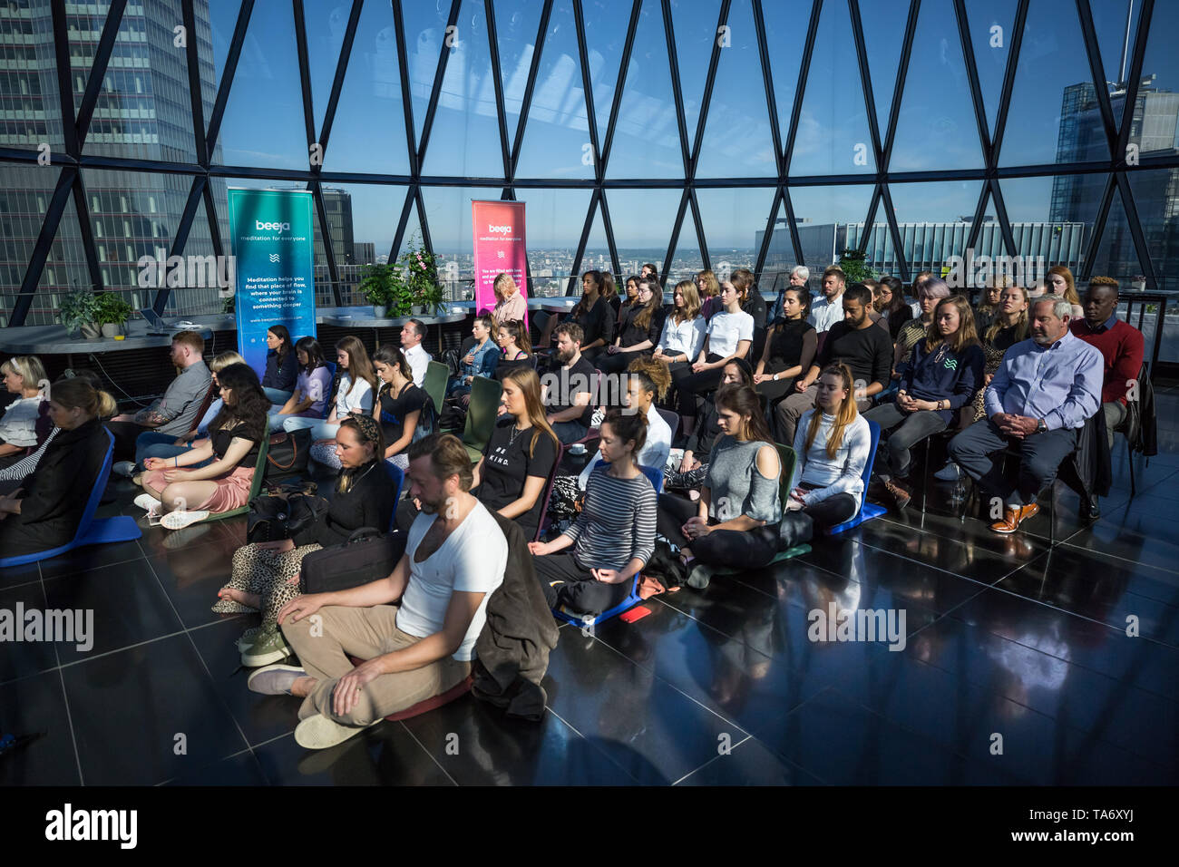 Mondo giorno meditazione eseguita nella parte superiore dell'edificio Gherkin guidato da meditazione guru sarà Williams. Londra, Regno Unito. Foto Stock