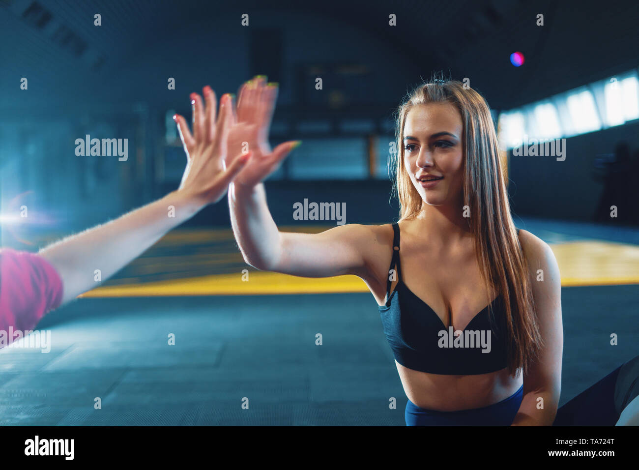 Giovani ragazze attraenti dando cinque a sport palestra sfondo Foto Stock
