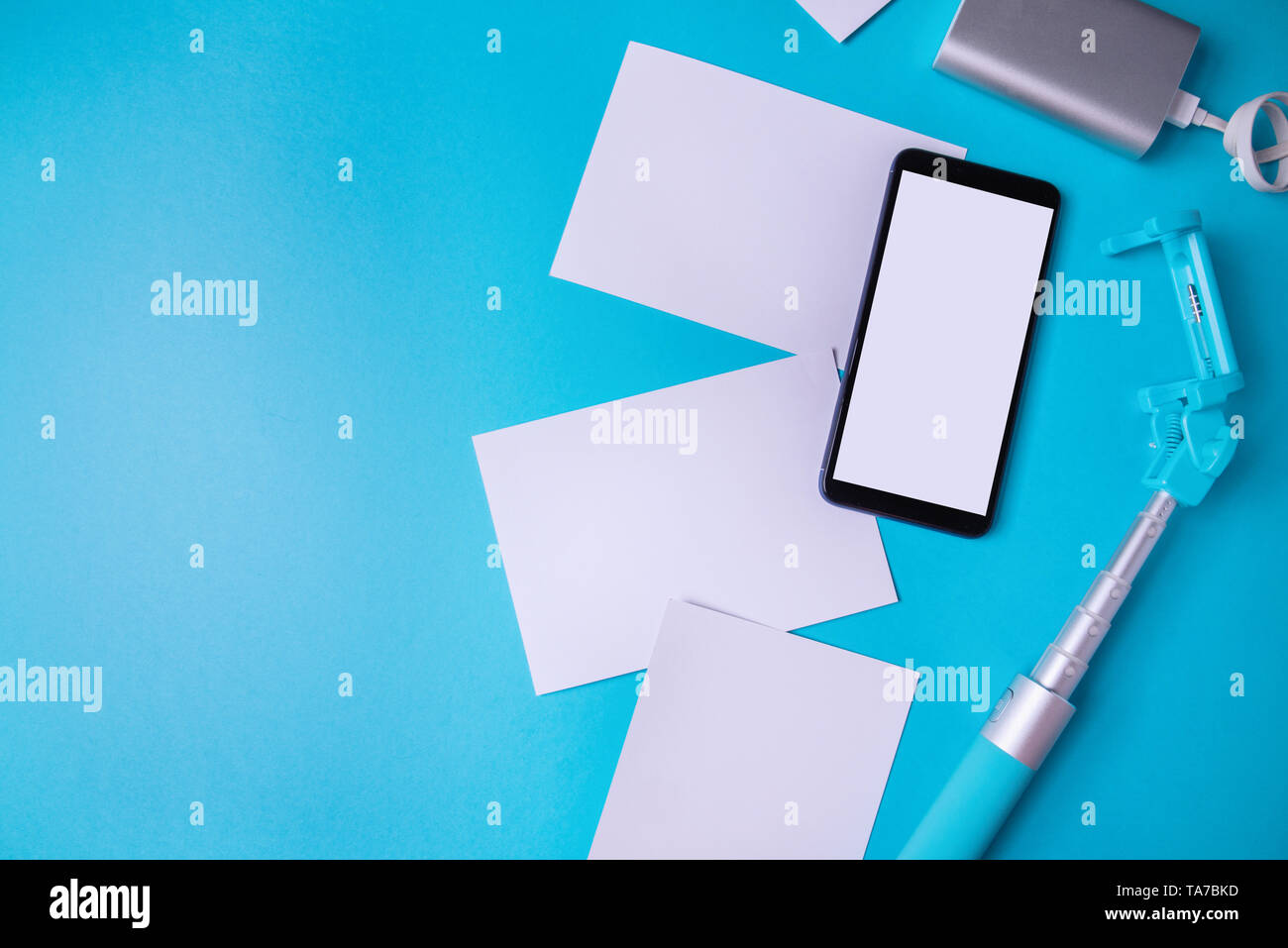 Smartphone con schermo vuoto e foto su uno sfondo blu. Mock up, laici piatta Foto Stock