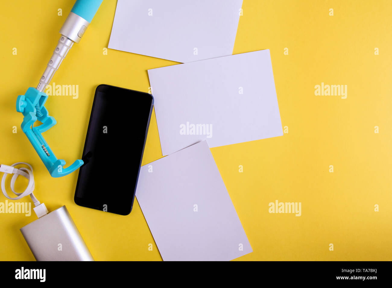 Piatto monopiede laici, smartphone e foto su uno sfondo giallo. concetto di viaggio Foto Stock