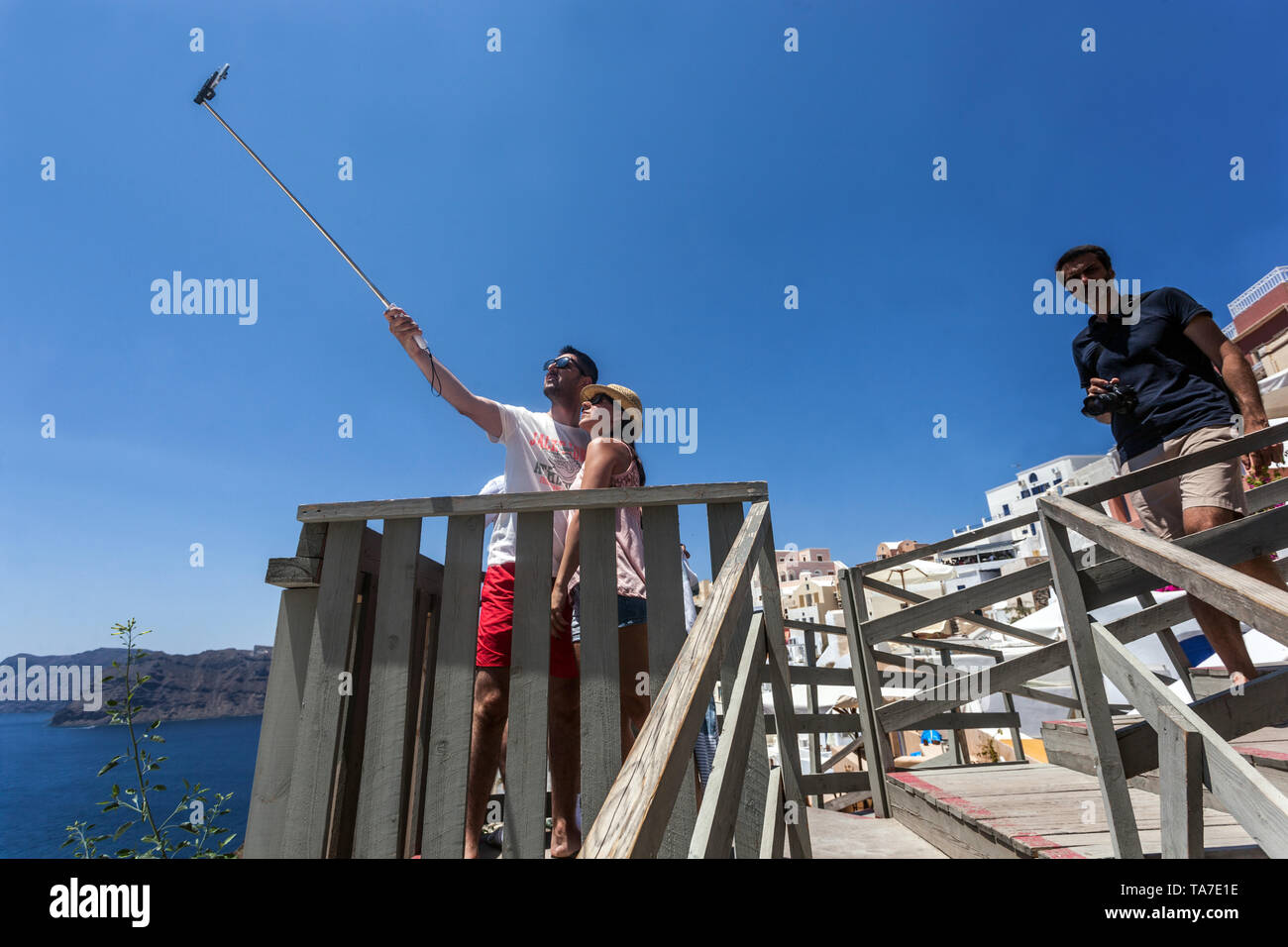 Santorini, persone turisti tenendo selfie sopra il mare e le isole greche, Grecia Europa Foto Stock