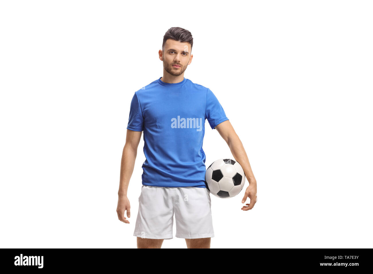 Giocatore di calcio tenendo un calcio e guardando la telecamera isolata su sfondo bianco Foto Stock