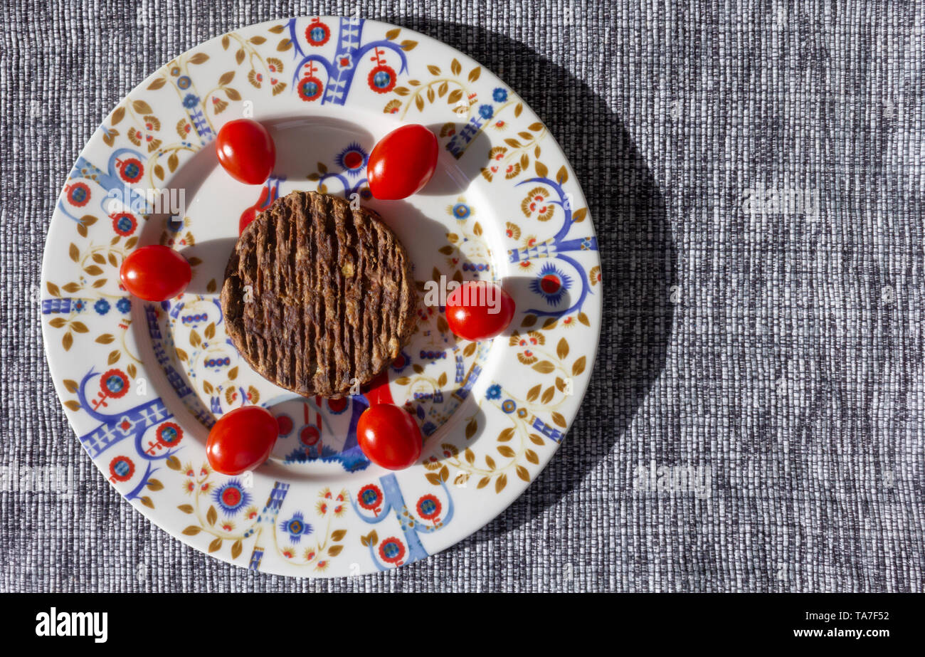 Carne vegetariani-free burger con pomodori in una bella piastra in orizzontale Foto Stock