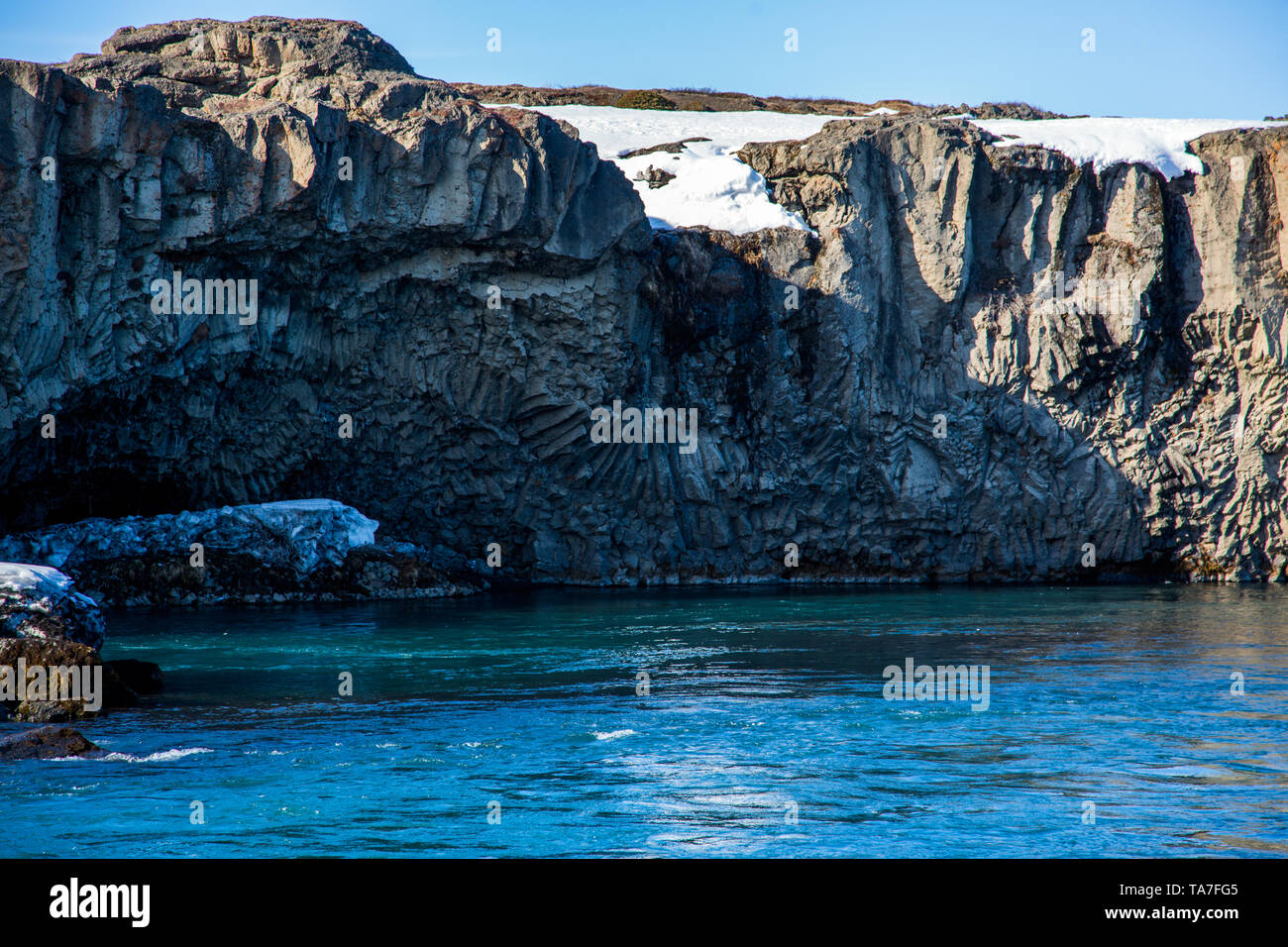 Basalto colonnare formazione su acque turchesi con tempo soleggiato in Islanda Foto Stock