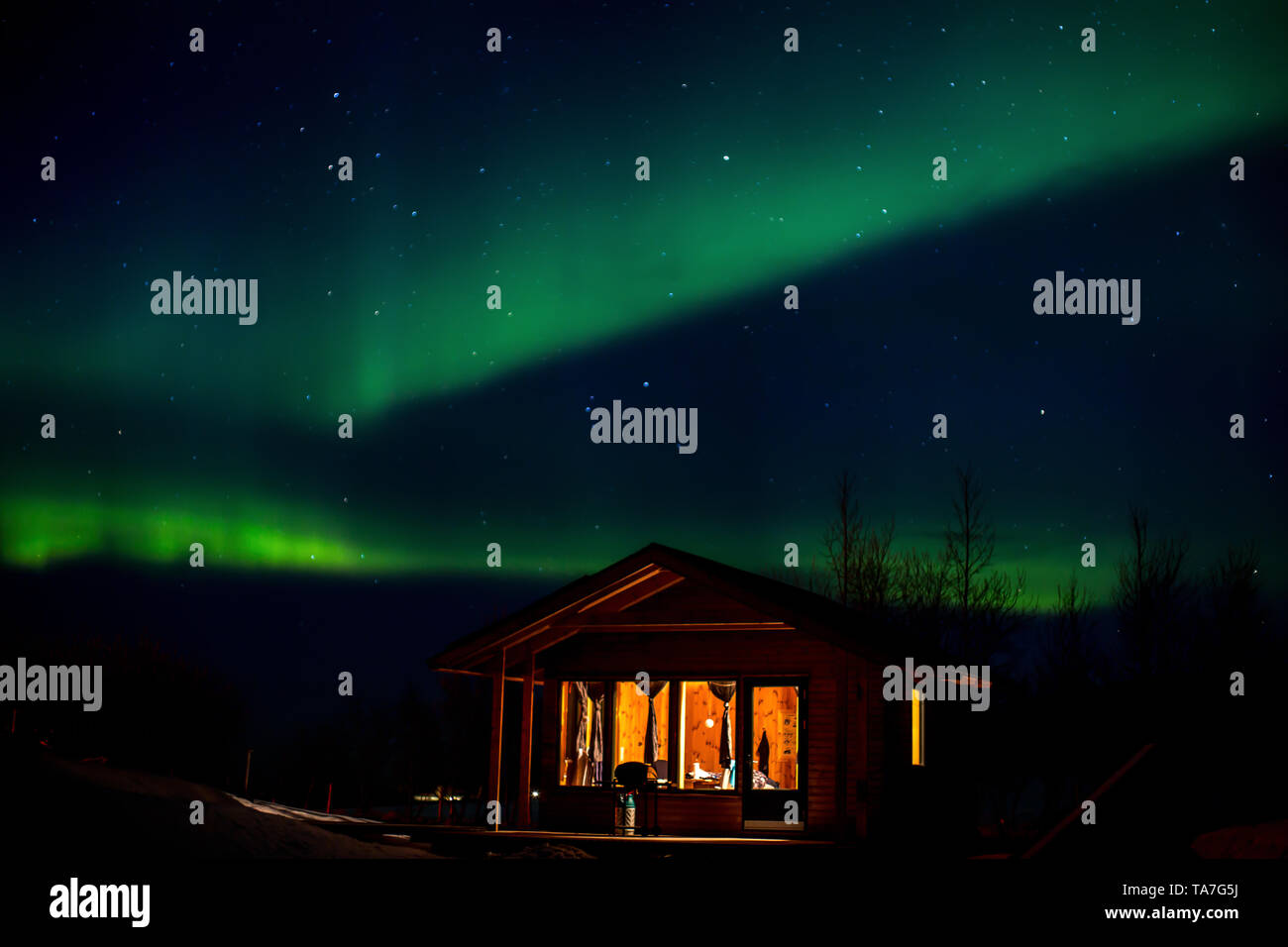 Ballo lighDancing polare luci polari con bungalow in primo piano in inverno in Icelandts, bungalow in primo piano Foto Stock