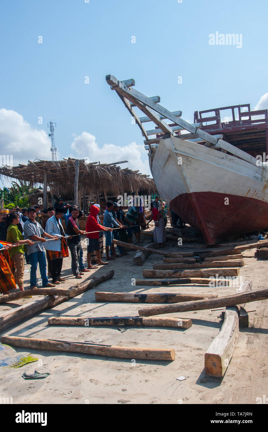 Bulukumba, Indonesia - 13 Settembre 2018: persone stanno tirando e spingendo una barca pinisi seaward durante Pinisi Internazionale Festival 2018 in Bulukumba Foto Stock