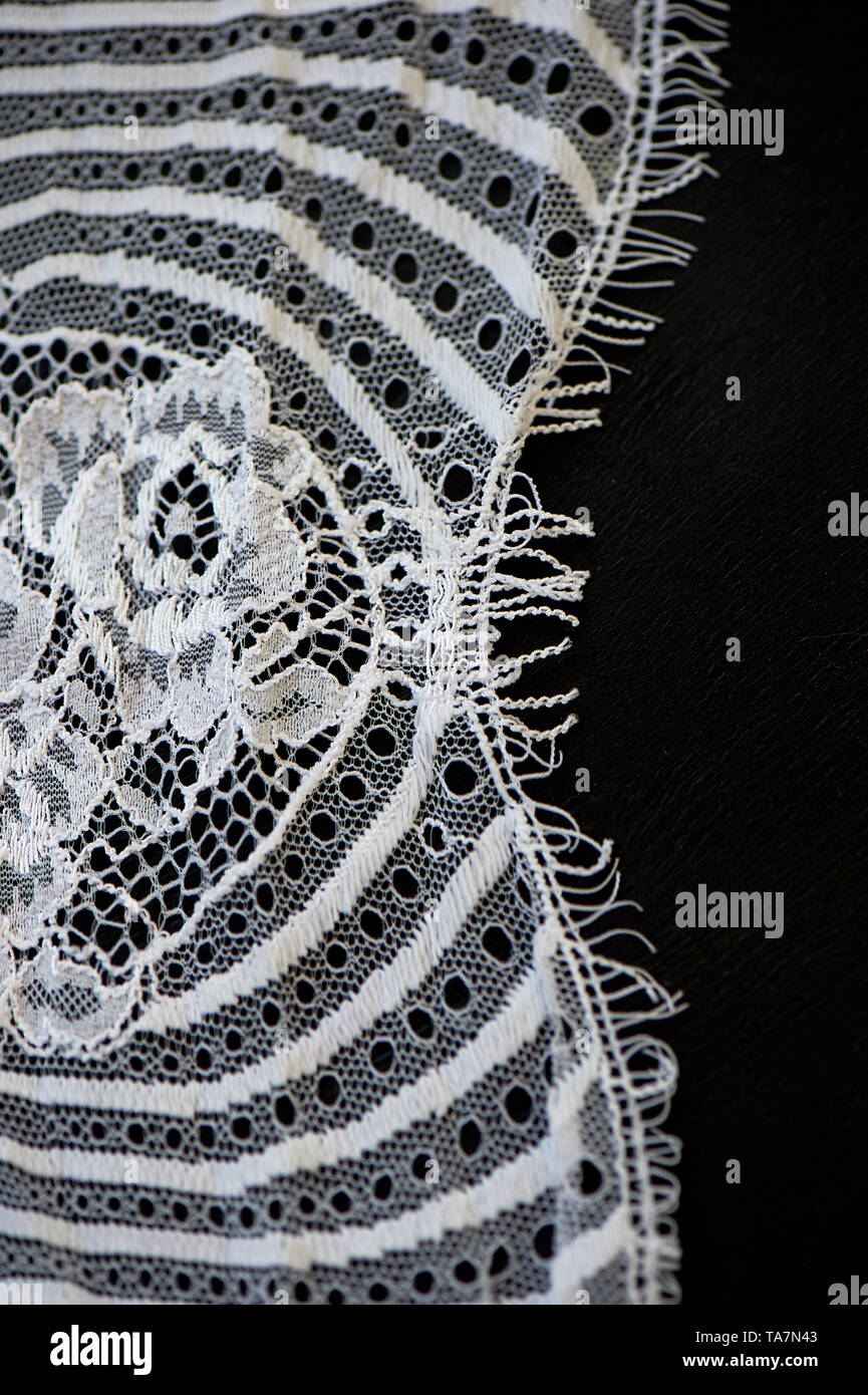 Pizzo bianco su sfondo nero. La texture è vicino. Foto Stock