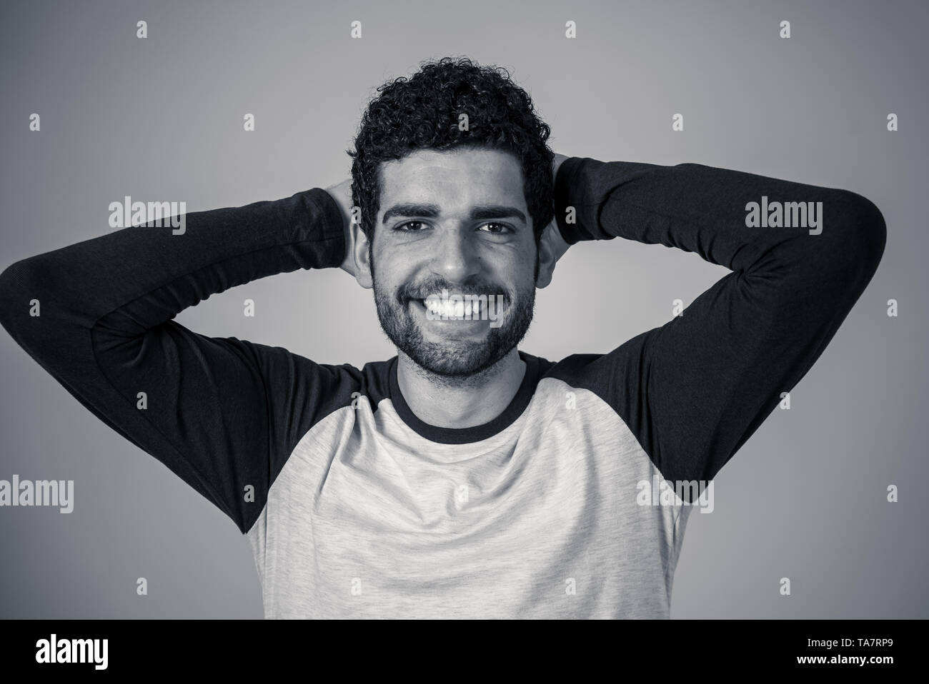Ritratto di giovane attraente modello con faccia felice e bel sorriso. Bello hipster barbuto l uomo nella sua 20s. Studio shot. In Persone, moda e h Foto Stock