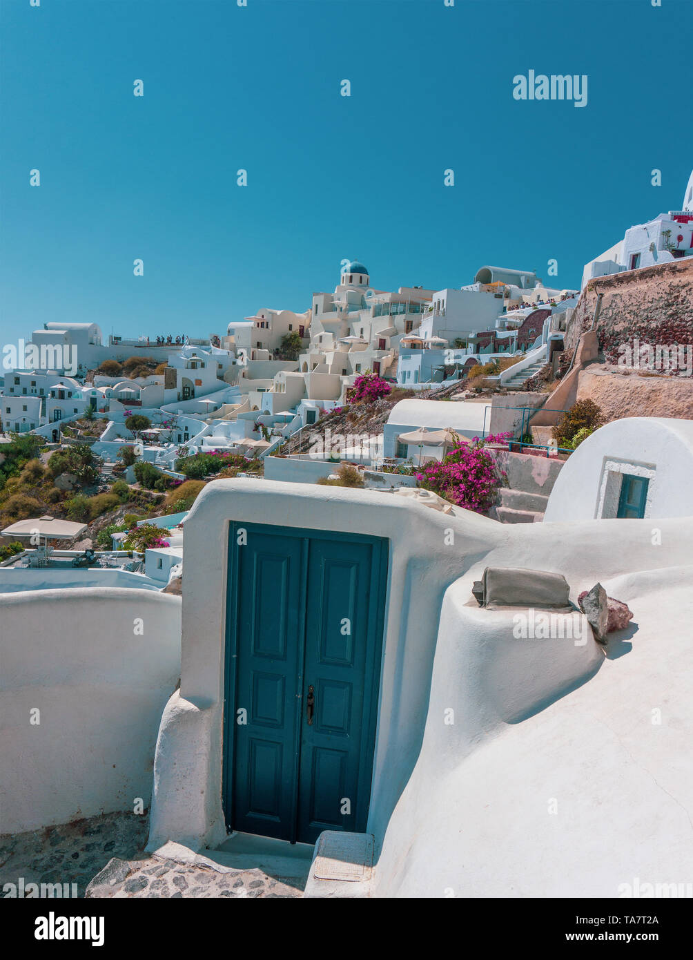 Verticale paesaggio colorato di Oia Santorini con una porta blu Foto Stock