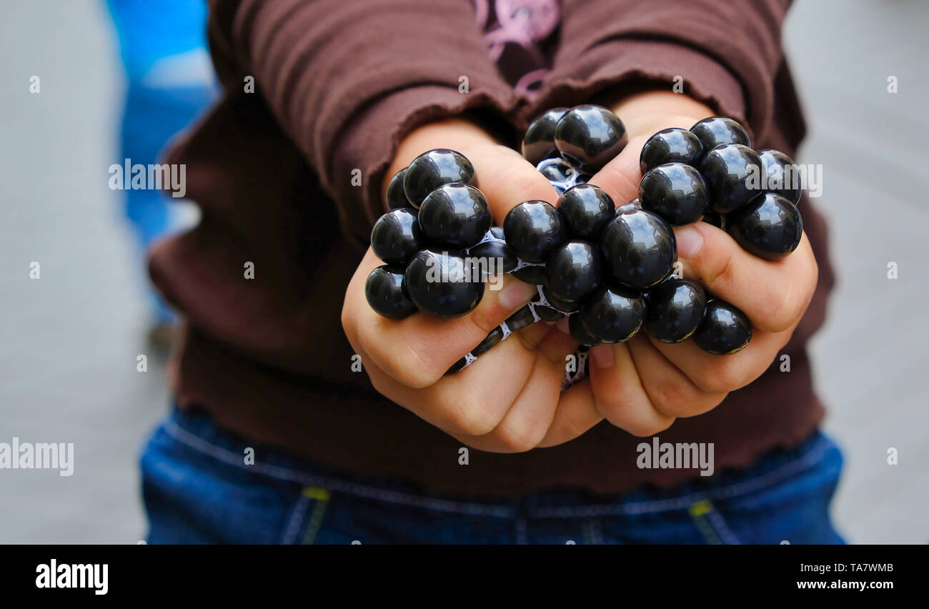 Le mani di una ragazza con marmi sulla strada Foto Stock