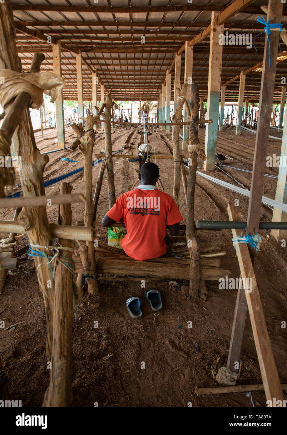 L'uomo africano dalla tribù Senufo tessitura in un tradizionale fabbrica tessile, Savanes distretto, Waraniene, Costa d'Avorio Foto Stock