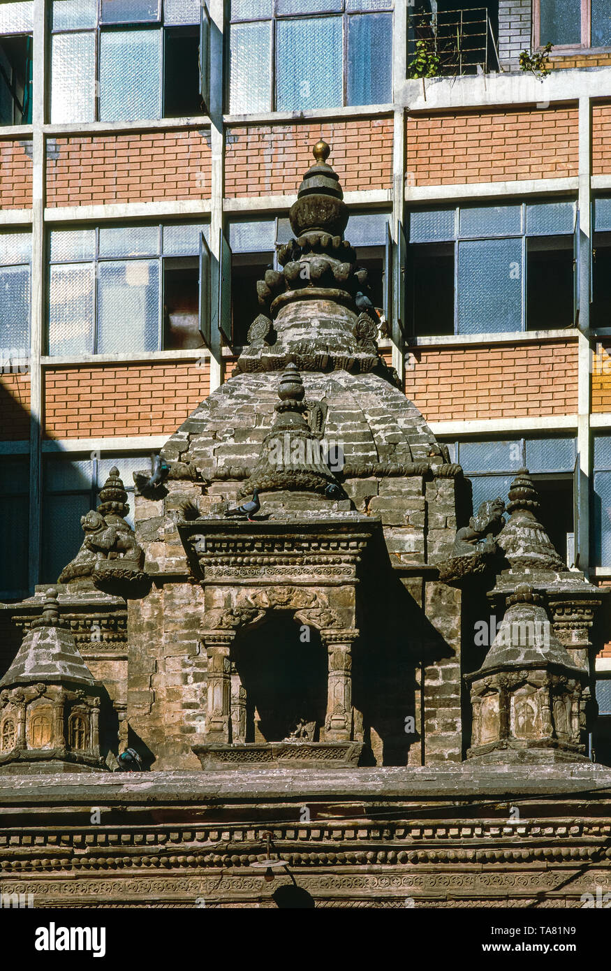 stupa in pietra vecchia in contrasto con un edificio moderno. Fotografia analogica. kathmandu, Nepal Foto Stock