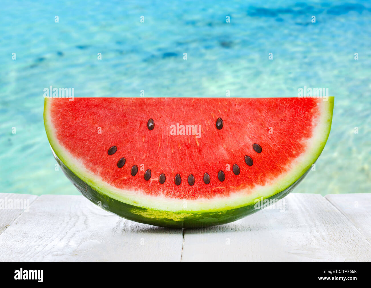 Anguria con semi di smiley. Sfondo con mare cristallino, estate food concept. Foto Stock