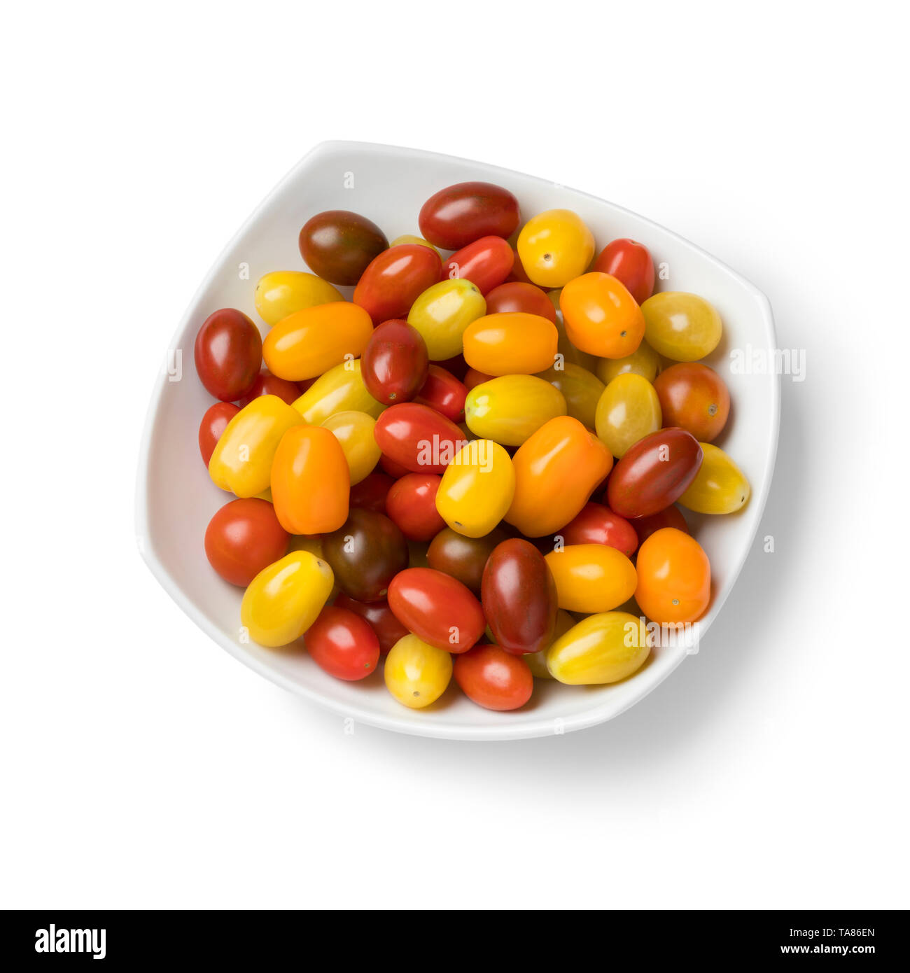 Piastra con un mix di colorful ripe pomodorini isolati su sfondo bianco Foto Stock