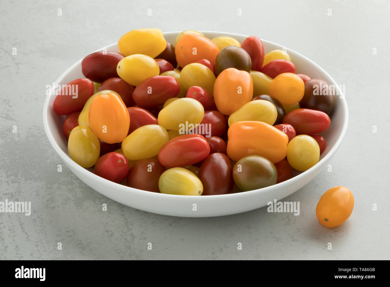 Piastra con un mix di colorful ripe pomodorini Foto Stock