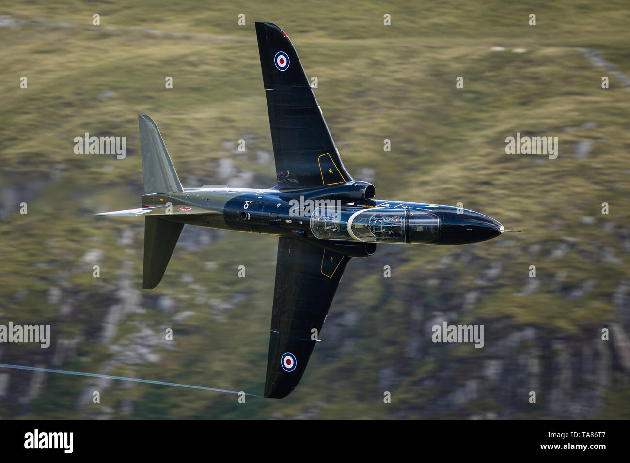 RAF Hawk volare basso livello attraverso il loop di Mach in Galles, Regno Unito Foto Stock