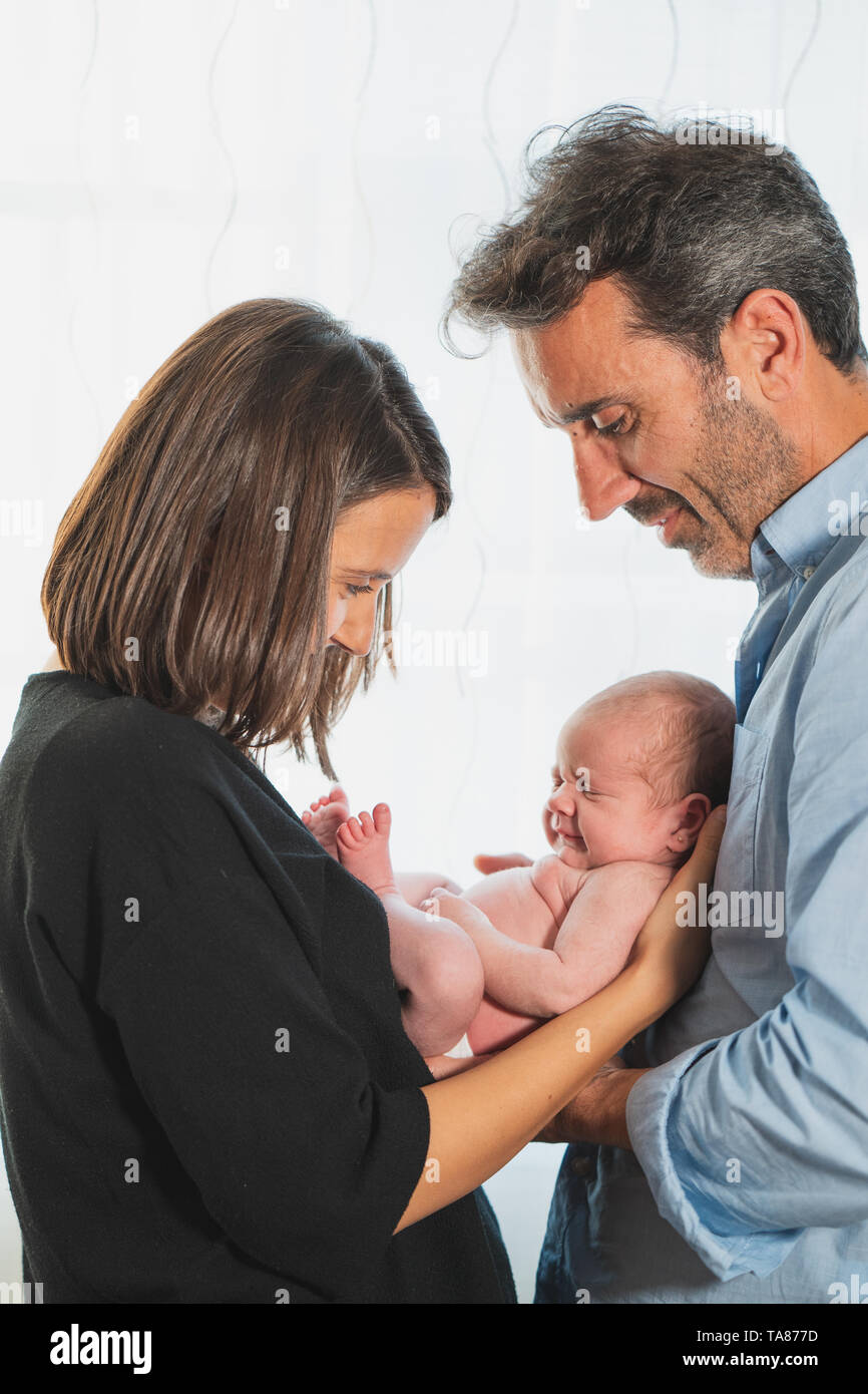 Il bambino neonato dormendo sui genitori le mani, nuovo nato Kid dormire in mano di famiglia, bambino madre padre su sfondo bianco Foto Stock