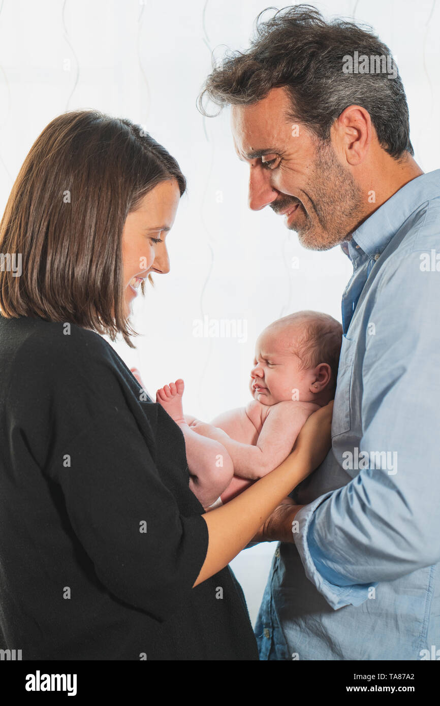 Il bambino neonato dormendo sui genitori le mani, nuovo nato Kid dormire in mano di famiglia, bambino madre padre su sfondo bianco Foto Stock
