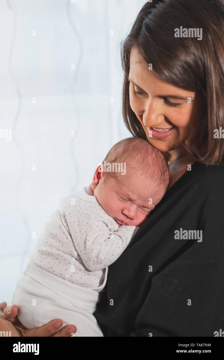 Nuova madre dorme il suo grazioso neonato adorabile sul suo giro. Il bambino esprime la calma e la pace. Famiglia, vita nuova, infanzia, inizio concetto. Foto Stock