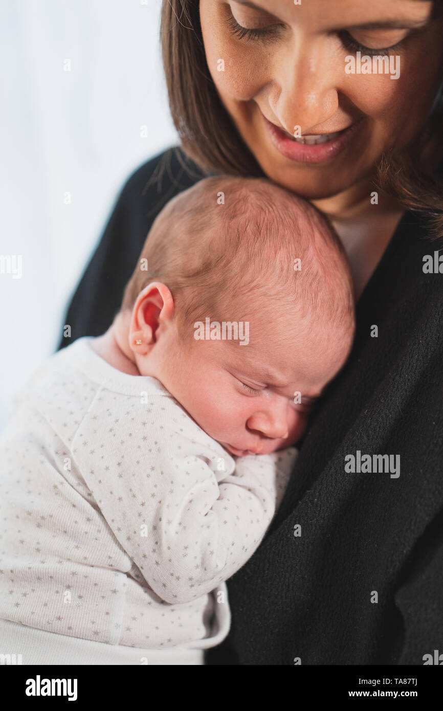 Nuova madre dorme il suo grazioso neonato adorabile sul suo giro. Il bambino esprime la calma e la pace. Famiglia, vita nuova, infanzia, inizio concetto. Foto Stock