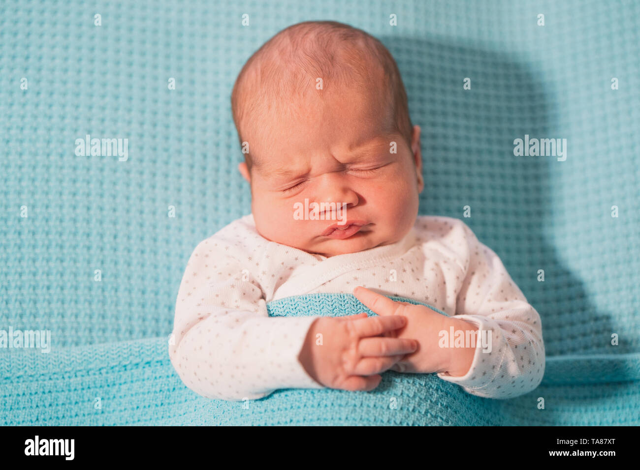 Piccolo bambino giacente su un letto su fogli di blu. Sweet Dreams. Foto Stock