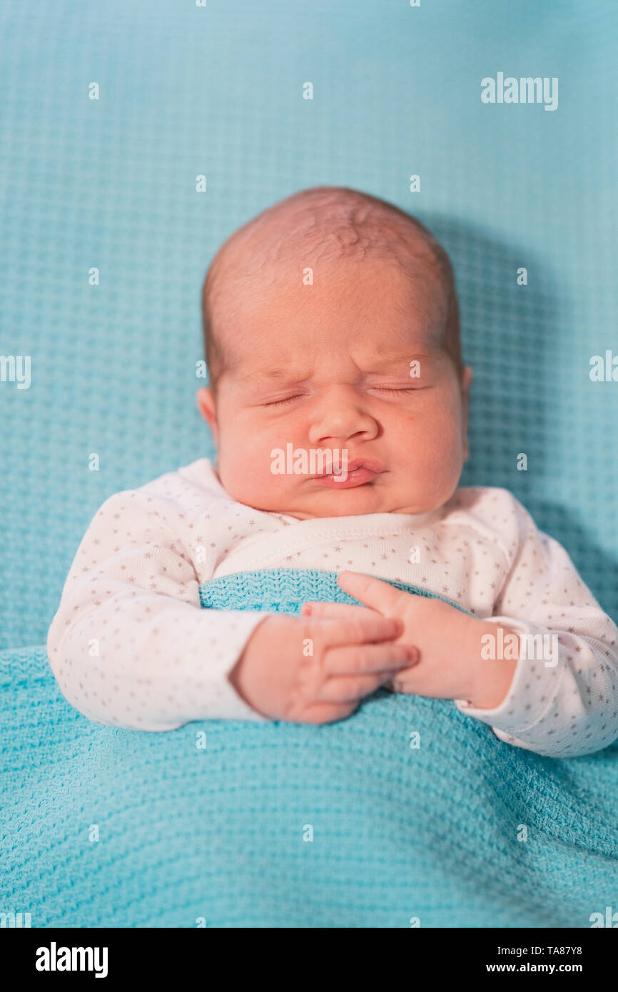 Piccolo bambino giacente su un letto su fogli di blu. Sweet Dreams. Foto Stock