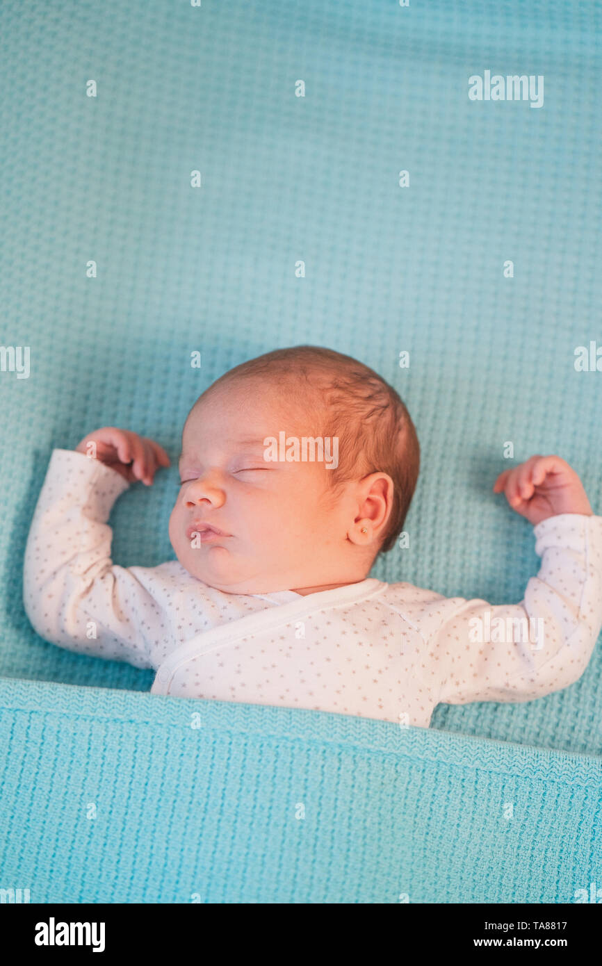 Poco carino bambino giacente a braccia aperte su un letto su fogli di blu. Sweet Dreams. Foto Stock