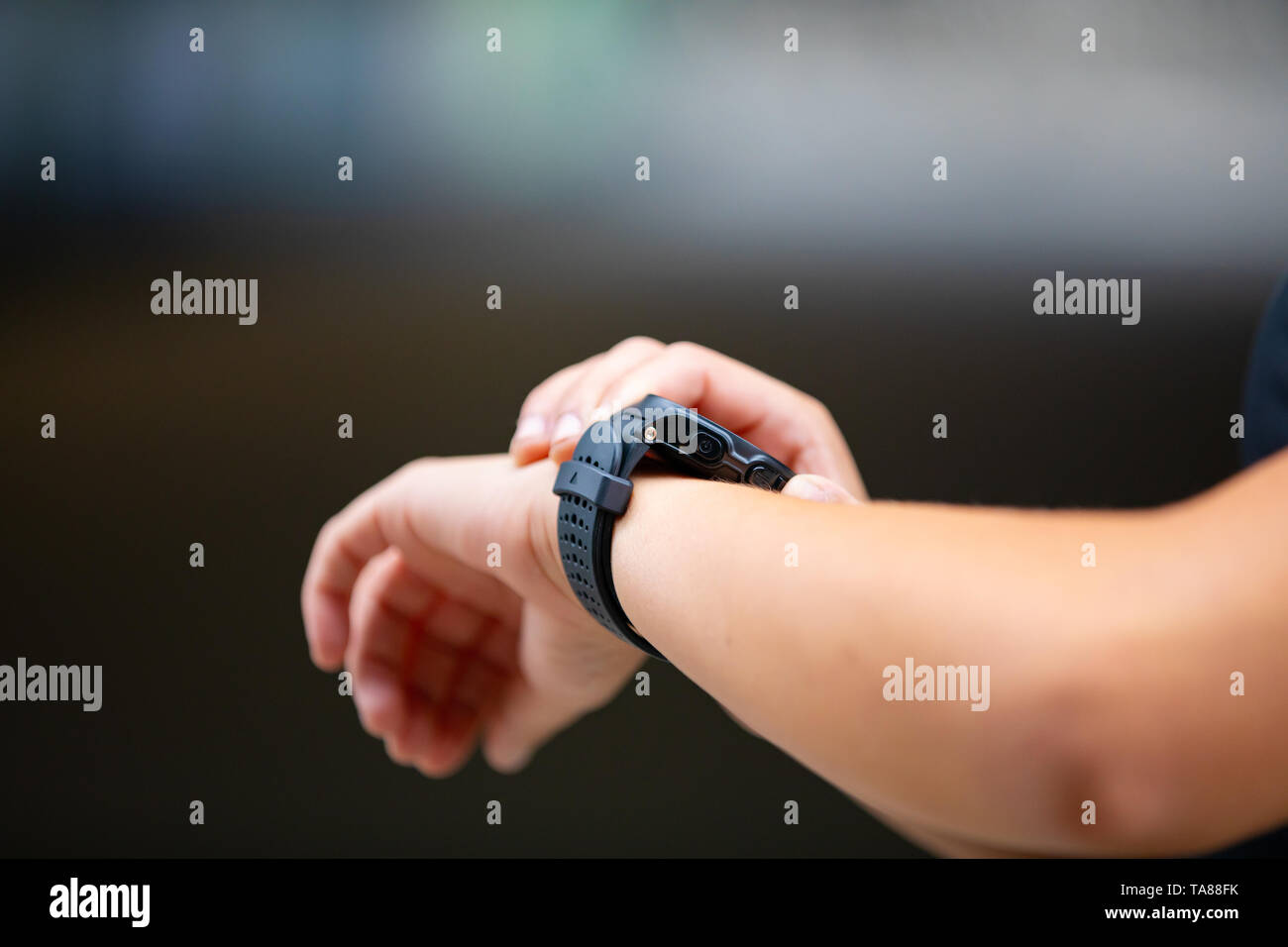 Mani femminili utilizzando smart fitness guarda il dispositivo dopo aver acceso Foto Stock