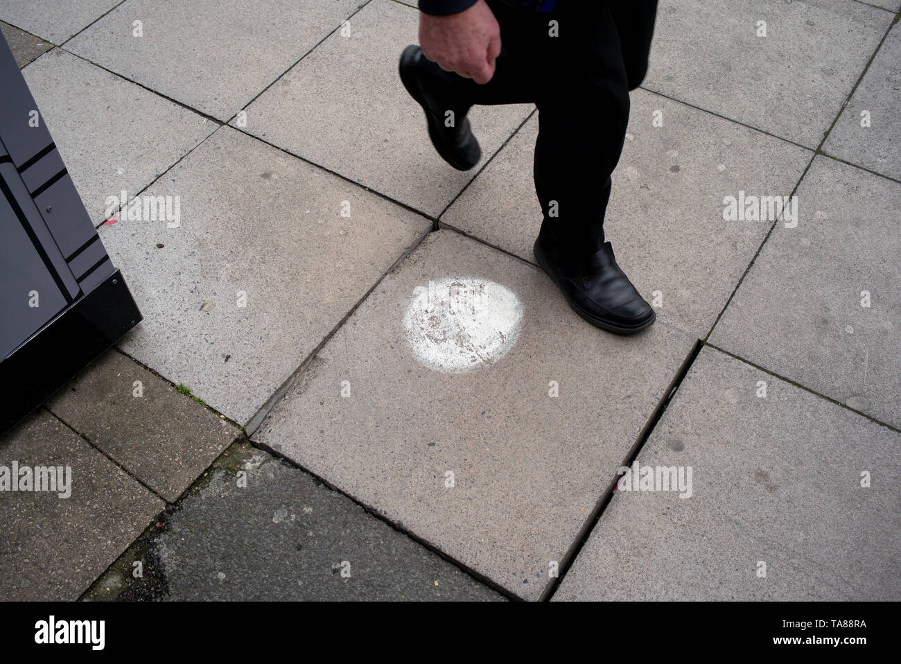 Una marcata pavimentazione in pietra con un punto di vernice su a gradini nel centro città di Southampton che necessita di attenzione come si muove ed è pericoloso come un pericolo di inciampare. Foto Stock