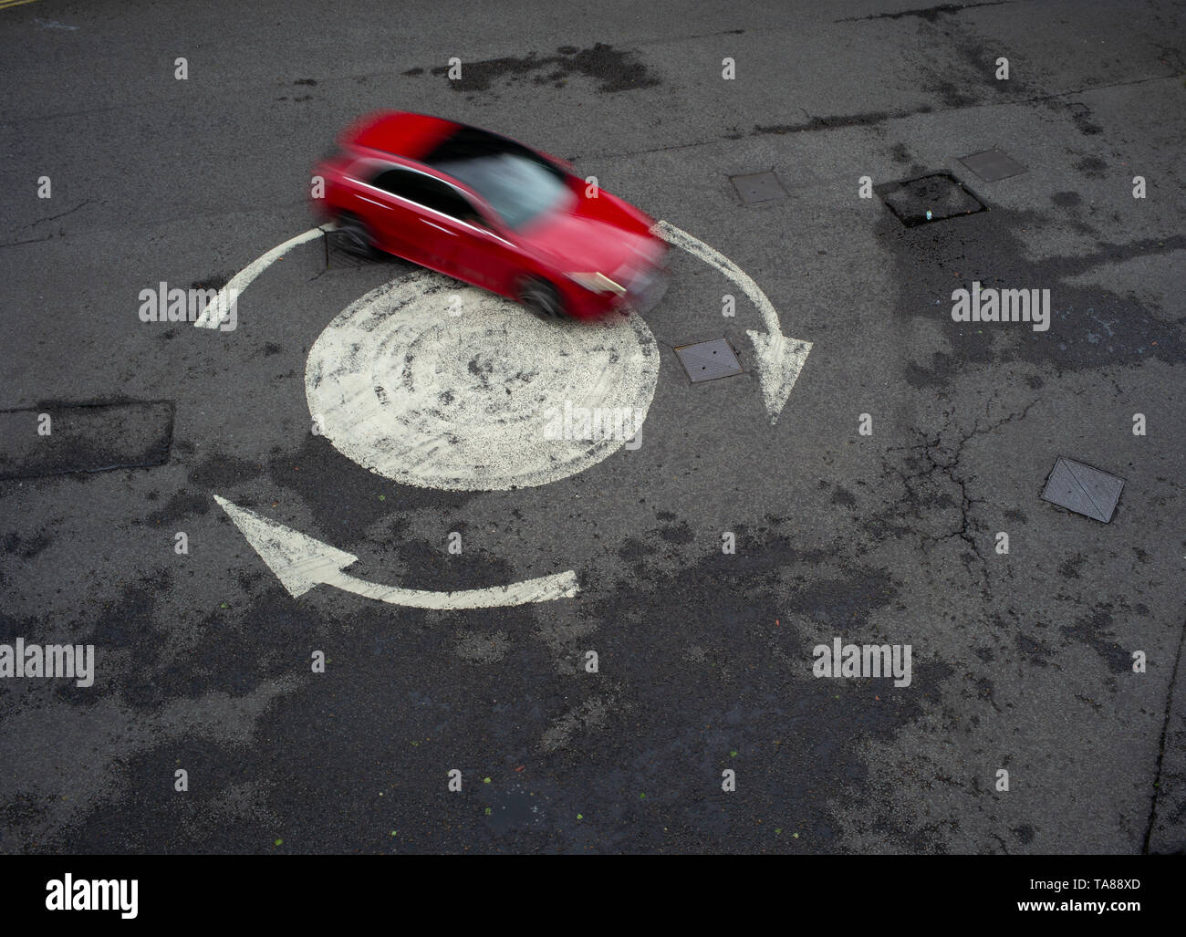 Vista aerea di un dipinto di freccia rotonda con una sola vettura andando in giro. Potrebbe essere usato come una analogia o nozione come perso o andando in cerchi. Foto Stock