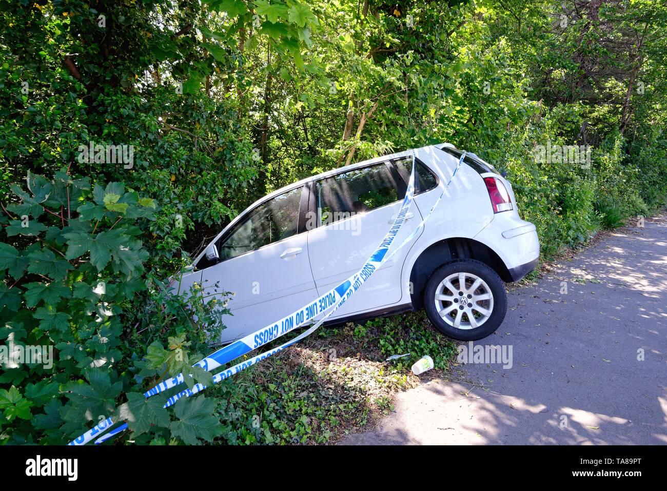 Un bianco berlina a faccia in giù in un fosso dopo schiantarsi su una strada principale, Shepperton Surrey in Inghilterra REGNO UNITO Foto Stock