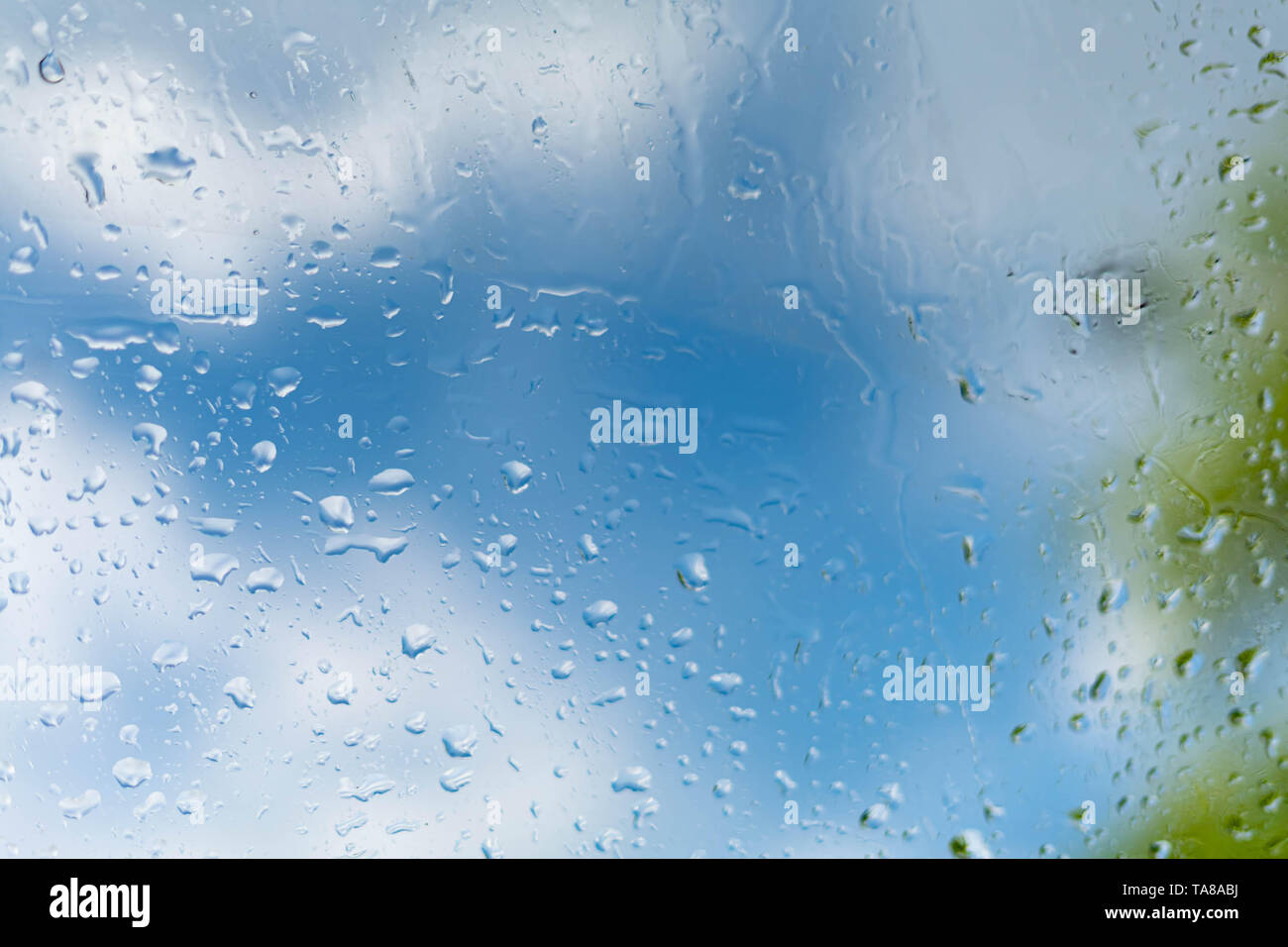 Gocce di pioggia su una finestra un cielo blu di una nuvola. Foto Stock