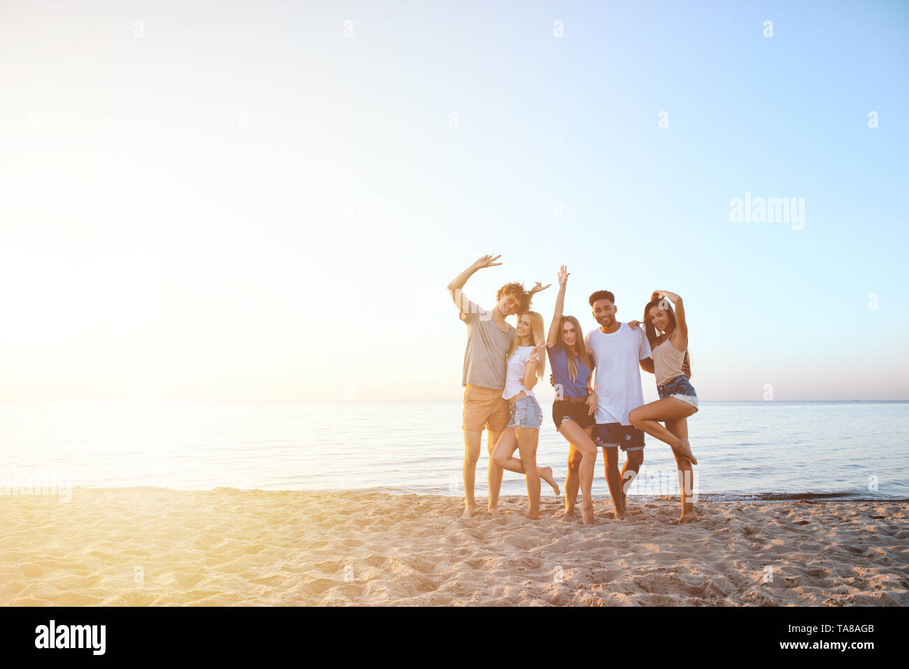 Gruppo di happy amici divertendosi a Ocean Beach all'alba Foto Stock
