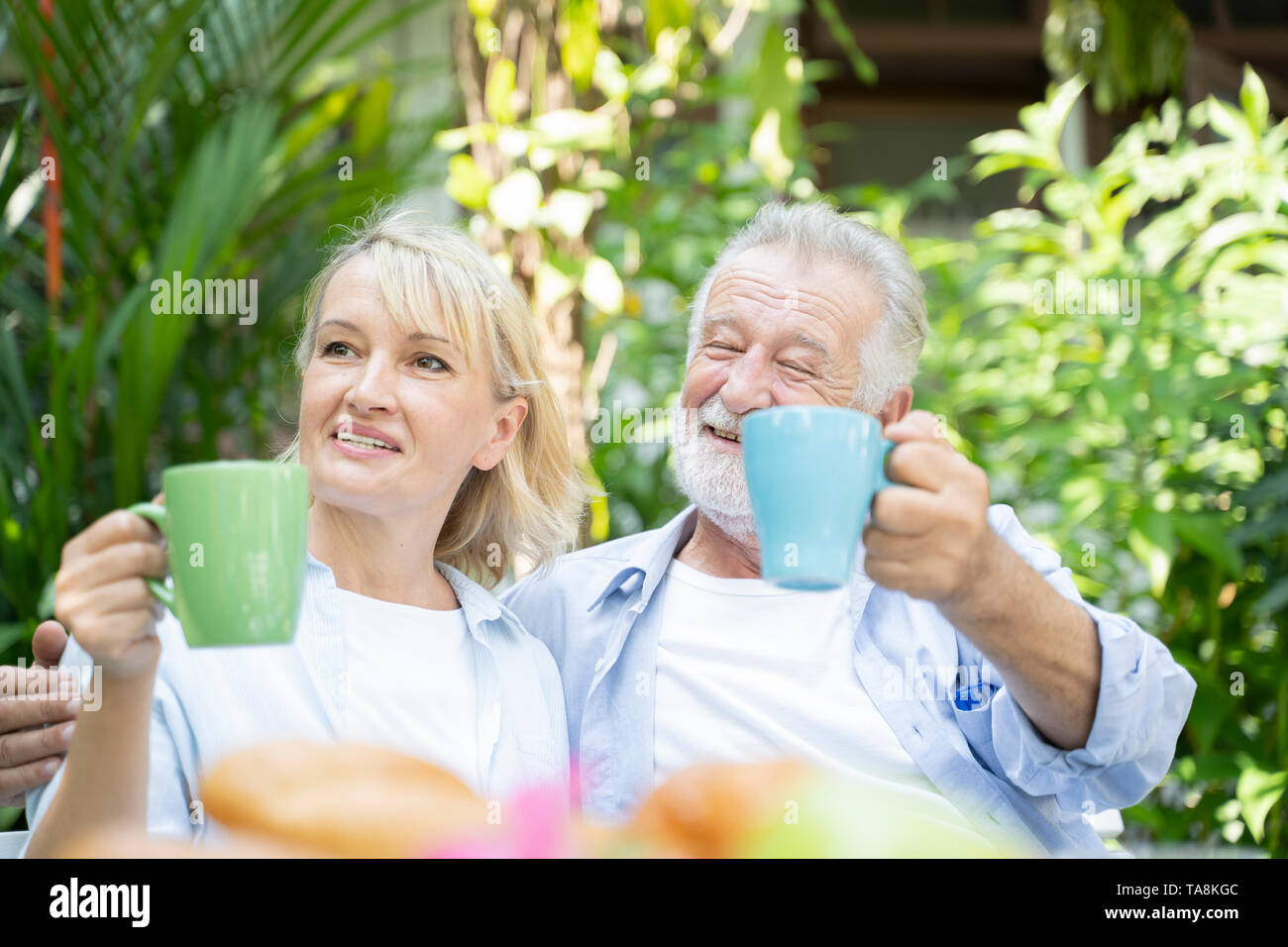 Momenti felici. Gioioso età pensionabile bella coppia avente il tè e ridere mentre godendo il loro tempo insieme - Immagine Foto Stock