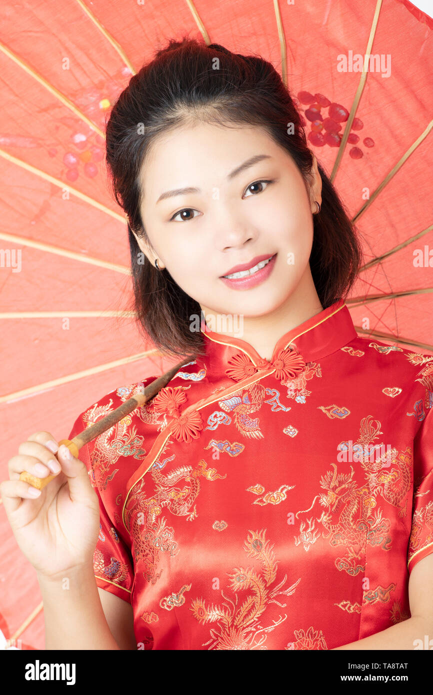 Bella donna cinese che indossa un abito tradizionale noto come un Cheongsam o Chipao isolato su uno sfondo bianco Foto Stock
