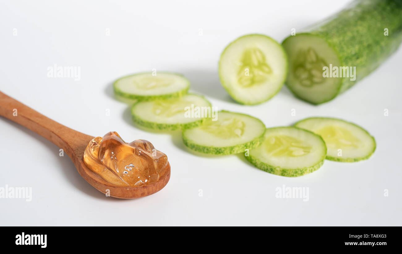 Organici skincare naturale concetto. Clear gel trasparente in cucchiaio di legno con Cucumber Slice isolati su sfondo bianco Foto Stock