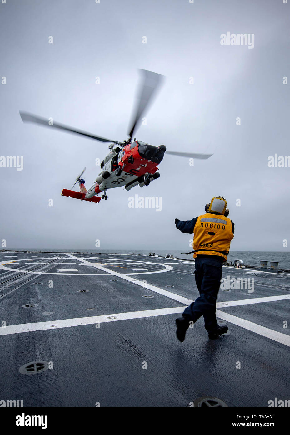 190518-N-EH218-1307 GOLFO DI ALASKA (18 maggio 2019) di Boatswain mate 1. Classe Robertus Sulistiono, da Los Angeles, dirige un U.S. Coast Guard MH-60T Jayhawk, assegnato a U.S. La guardia costiera della stazione aria Kodiak, prima di atterrare sul ponte di volo dell'Arleigh Burke-class guidato-missile destroyer USS Kidd (DDG 100) Pur partecipando in esercizio bordo settentrionale 2019. Il bordo settentrionale è uno di una serie di Stati Uniti Comando Indo-pacifico esercita nel 2019 che prepara le forze congiunte di rispondere alle crisi nella regione Indo-Pacifico. (U.S. Foto di Marina di Massa lo specialista di comunicazione 1a classe Ryan J. Batchelder Foto Stock